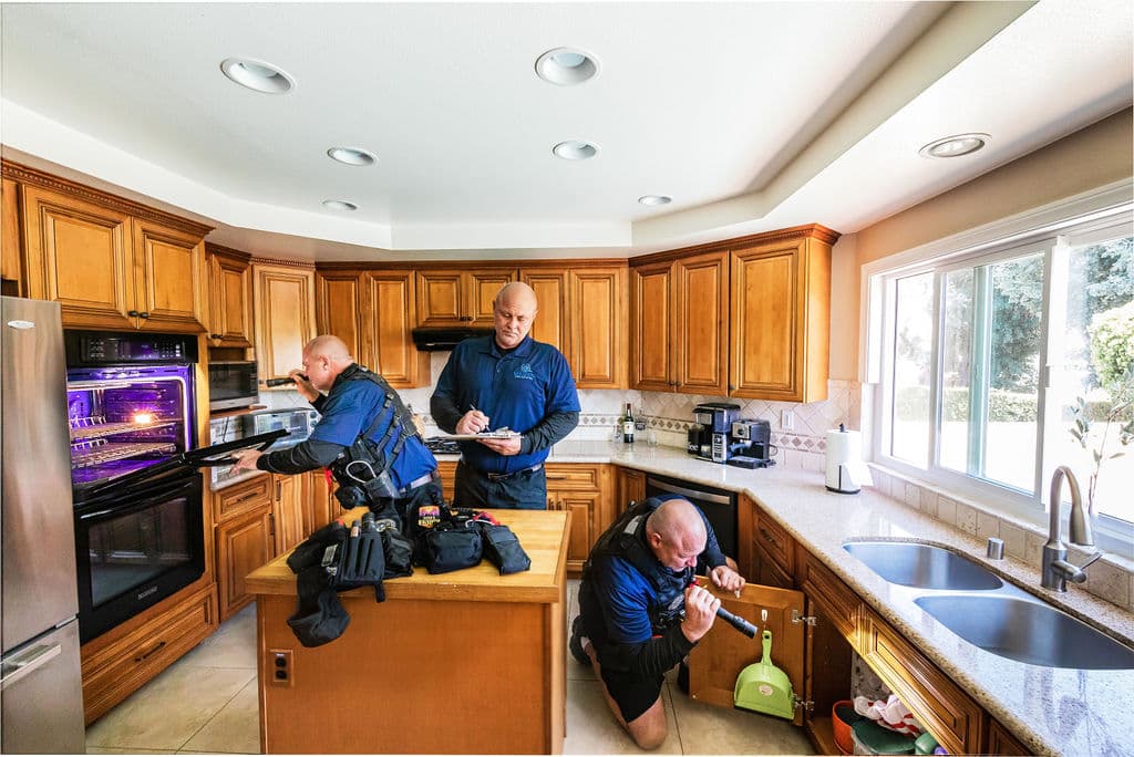 Trident Inspection Group team walking a homeowner through findings in the kitchen